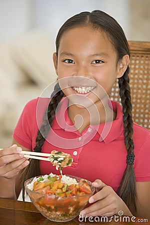 Young girl in dining room eating chinese food