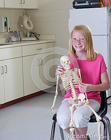 Young girl holding medical skeleton