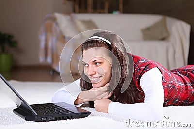 A young girl with a lap top at home