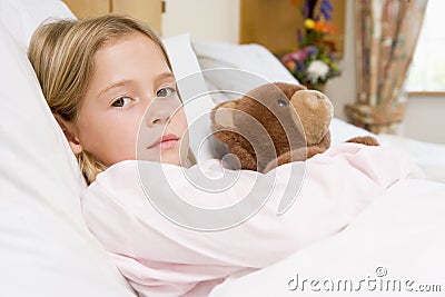 Young Girl Lying In Hospital Bed With Teddy Bear