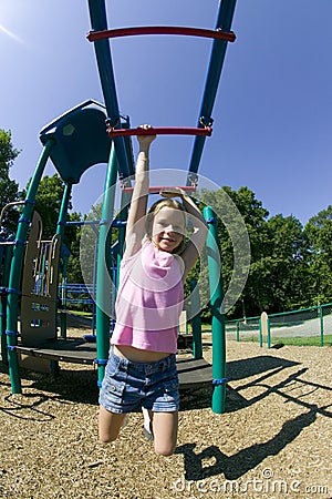 Young Girl Playing On Monkey Bars At The Par