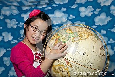 Young girl points to China on a globe