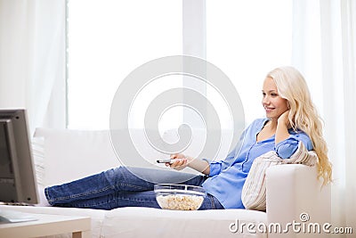 Young girl with popcorn watching movie at home