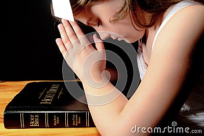 Young Girl Praying Over Bible