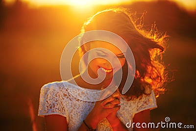 A young girl prays at sunset