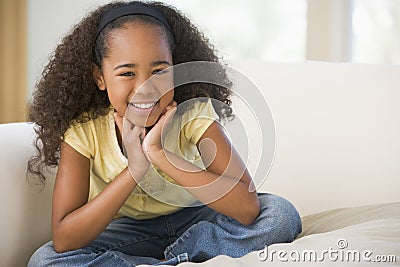 Young Girl Sitting Cross Legged On A Sofa At Home