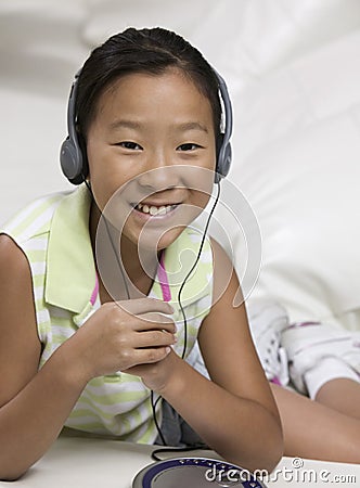 Young Girl on sofa Listening to portable CD player