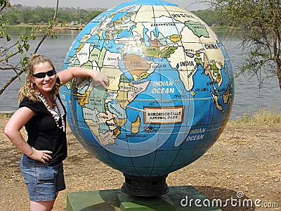 Young girl standing in front of giant world globe