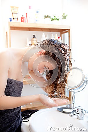 Young girl taking care of her hairs in a bathroom