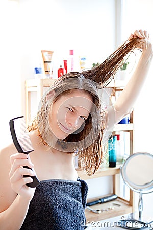 Young girl taking care of her hairs in a bathroom