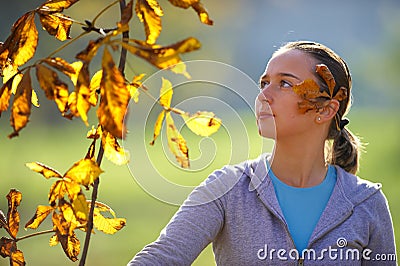 Young girl throws leaves