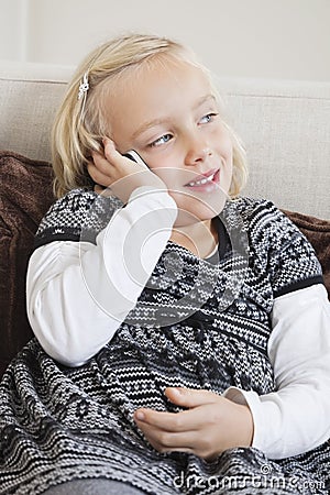 Young girl using cell phone on sofa