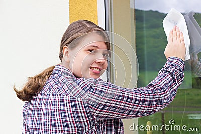 Young girl washing windows outside
