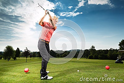 Young golf player on course doing golf swing