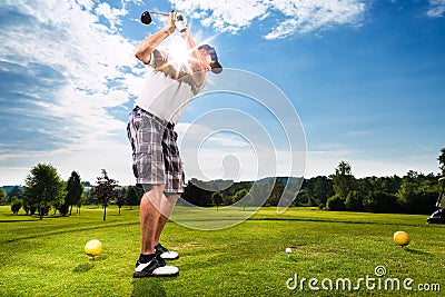 Young golf player on course doing golf swing