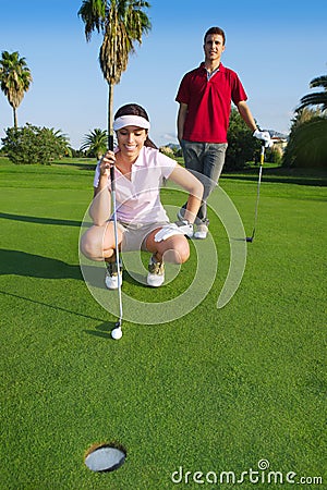 Young golf woman looking and aiming the hole