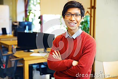Young handsome asian man with arms folded