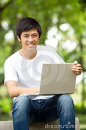 Young handsome Asian student with laptop