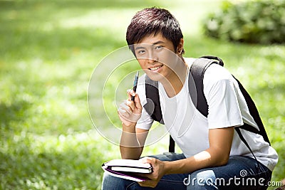 Young handsome Asian student with laptop