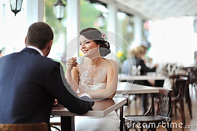 Young happy bride and groom at an outdoor cafe