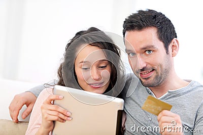 Young happy couple shopping on a tablet