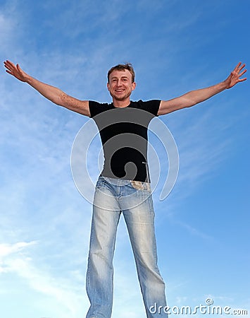 Young happy man with open arms outdoors