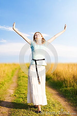 Young happy woman walking on a field