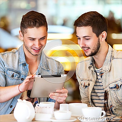 Young hipster guy sitting in a cafe chatting and drinking coffe