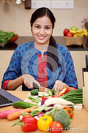 Young Indian woman cutting vegetables