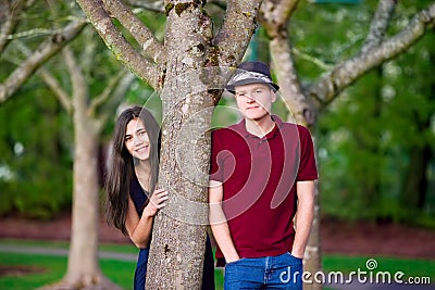 Young interracial couple standing by tree