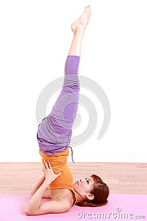 Young Japanese woman doing YOGA shoulder stand