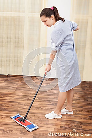 Young maid cleaning floor