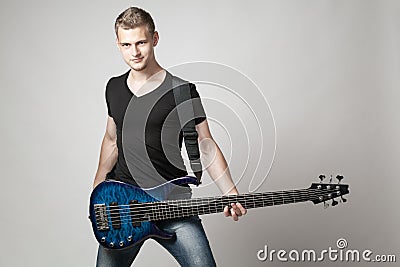 Young male musician with six-string bass guitar isolated