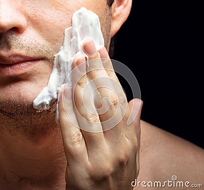 Young man applying a shaving foam