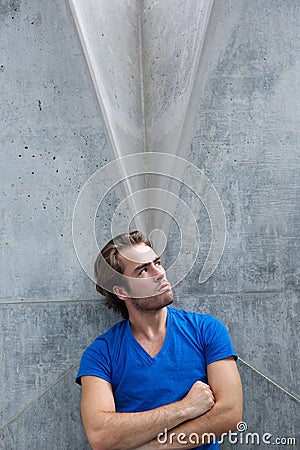 Young man with arms crossed looking up