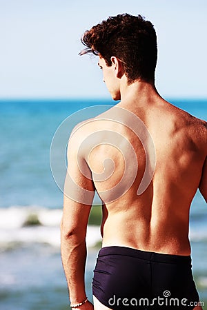 Young man from the back looking at the sea