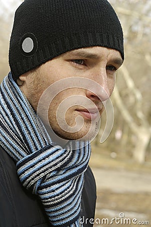 Young man in black cap and striped scarf