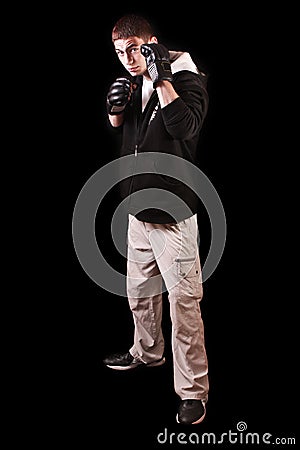 Young man in boxing gloves on black