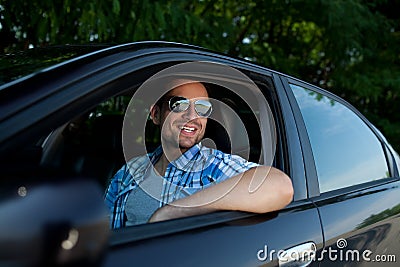 Young man in car smiling