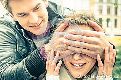 Young man covering the eyes of an happy surprised girlfriend