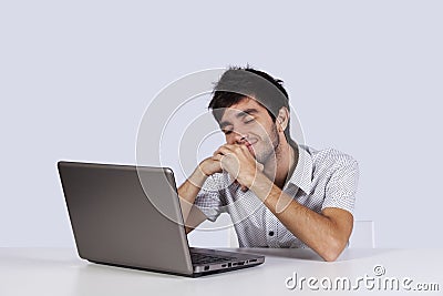 Young man dreaming in front of his laptop