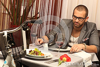 Young man enjoying meal with a a bike
