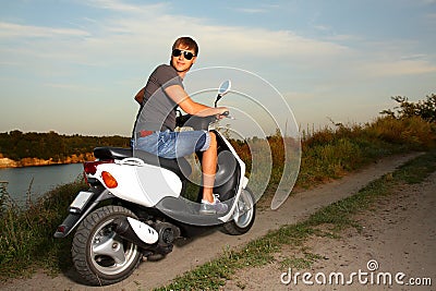 Young man in glasses for driving a scooter