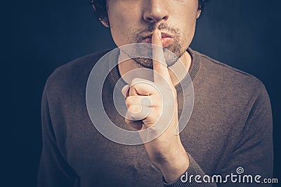 Young man with his finger on his lips