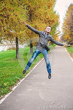 Young man jumping in autumn park