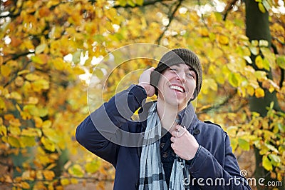 Young man laughing outdoors on an autumn day