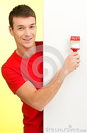 Young man painting wall in red.