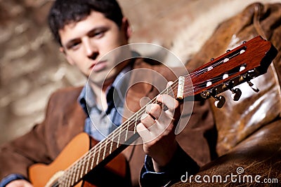 Young man playing on guitar