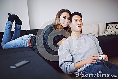 Young man playing video game with girlfriend