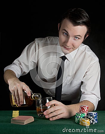 Young man pouring whiskey at the casino table